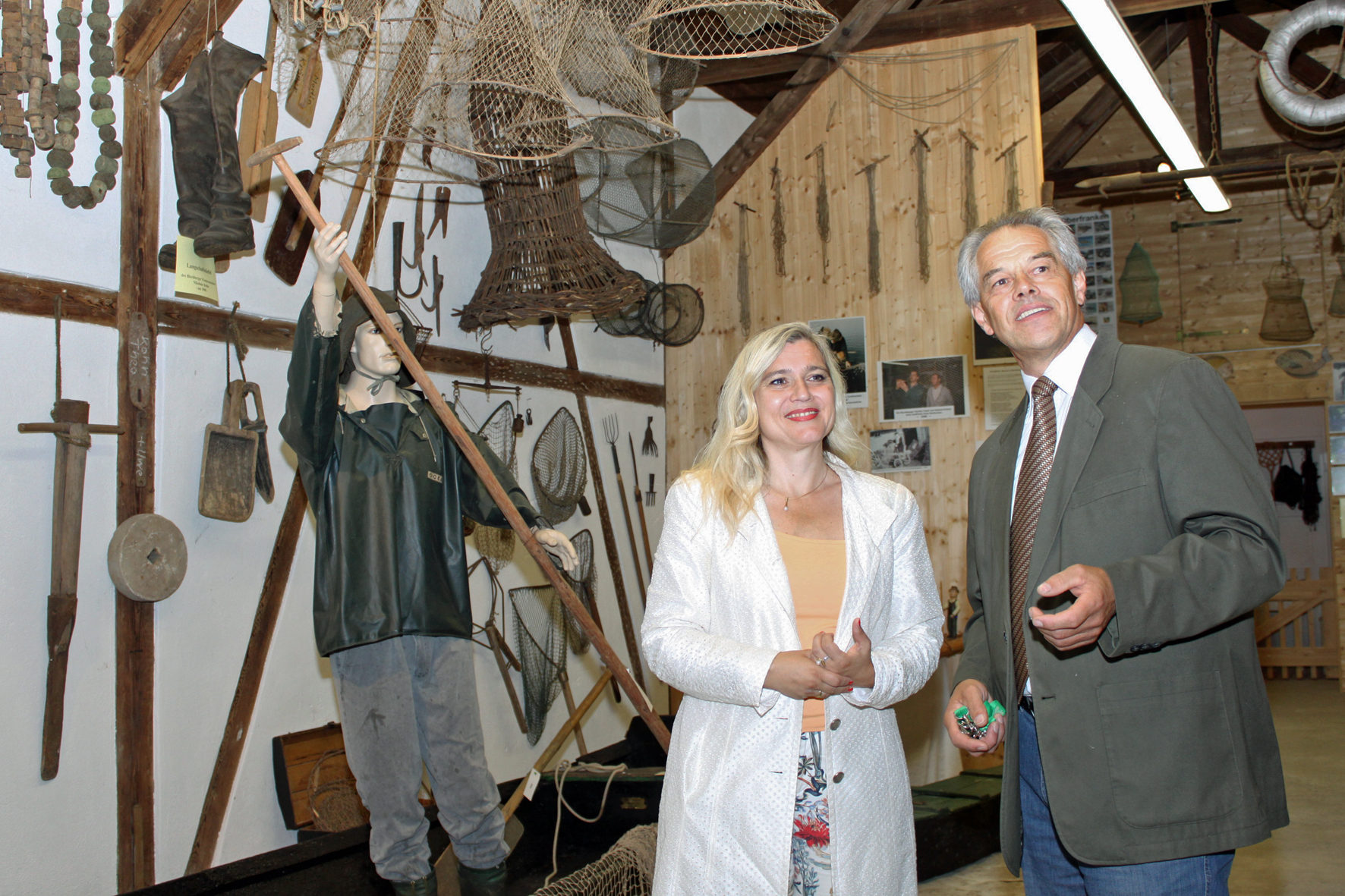 Josef Kröner führt Staatsministerin Melanie Huml durch das Fränkische Fischereimuseum in Bischerb